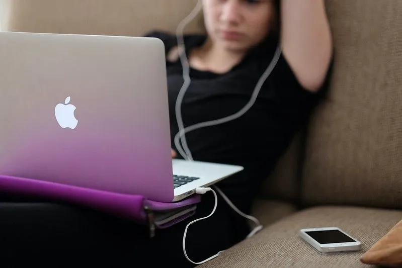 Teenage girl watching educational toys on her laptop.