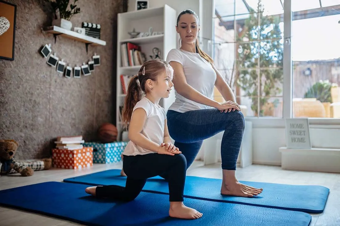 Mother and daughter practising yoga at home.