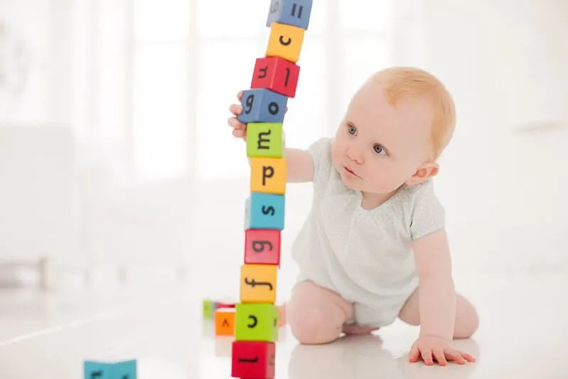 Toddler looking at building blocks.