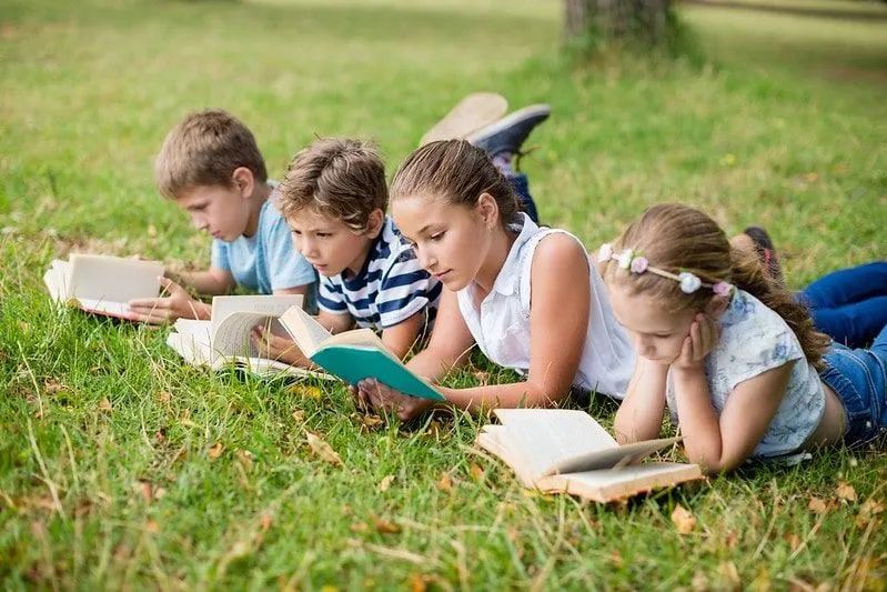 Children reading different Oxford Reading Tree levels in a field.