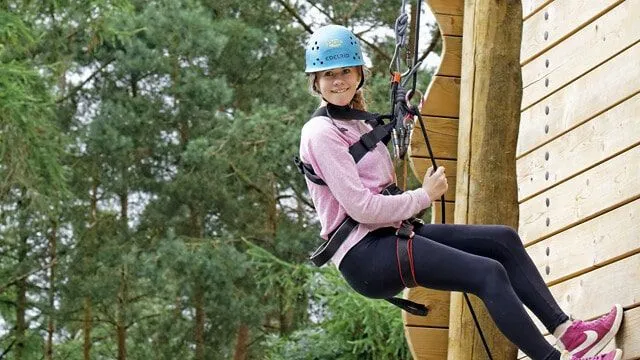 Girl abseiling at PGL while on family holiday with teenagers