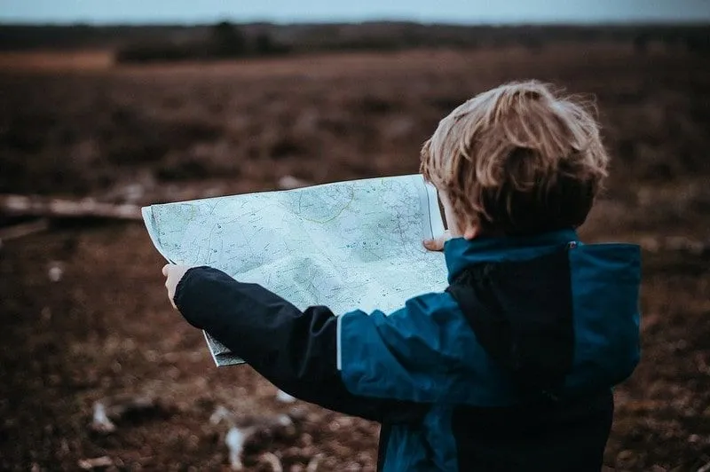 A young boy looking at a map.