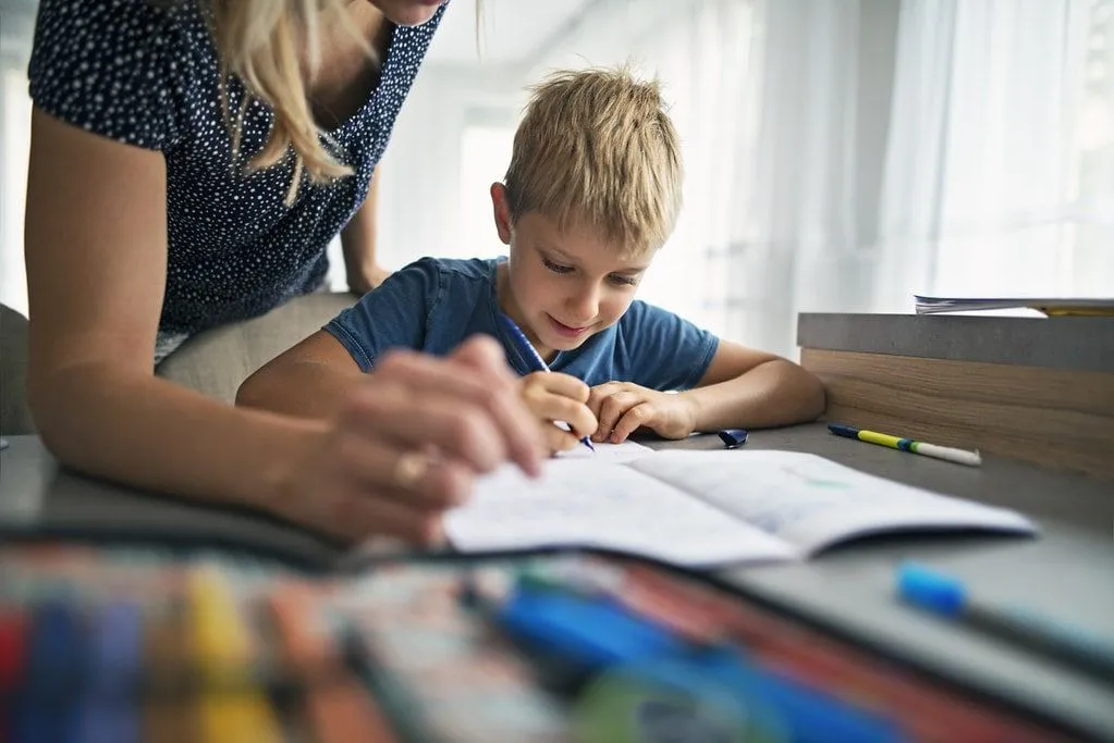 Boy sat at table doing homework learning mitochondria facts.