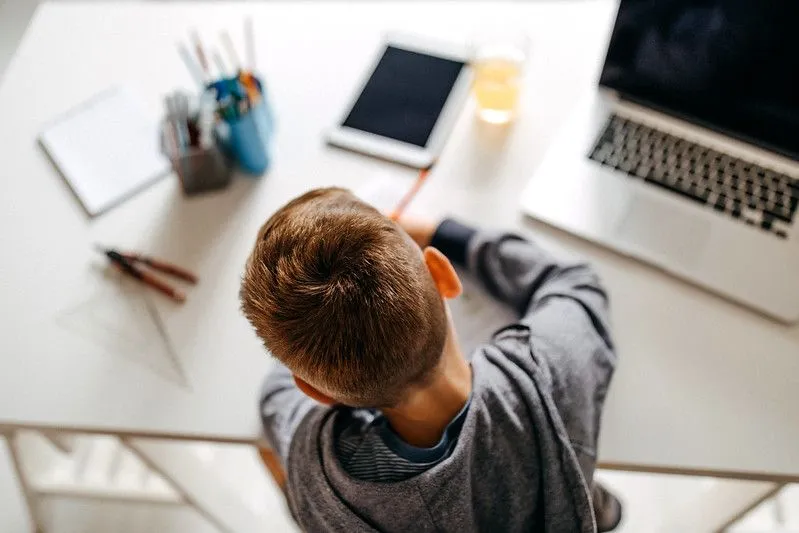 Boy studying on a desk chair at his desk