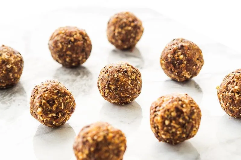 Energy balls lined on a tray, made with nuts and dates.