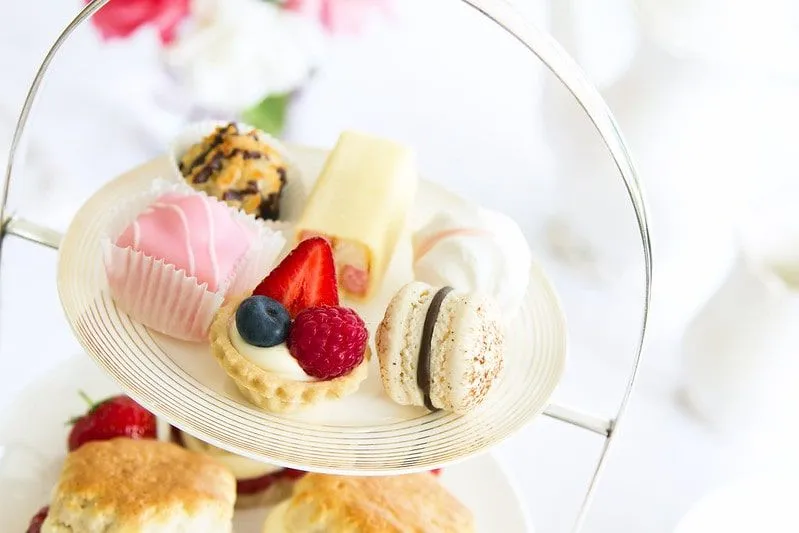 Assortment of cakes on a tiered platter at afternoon tea.