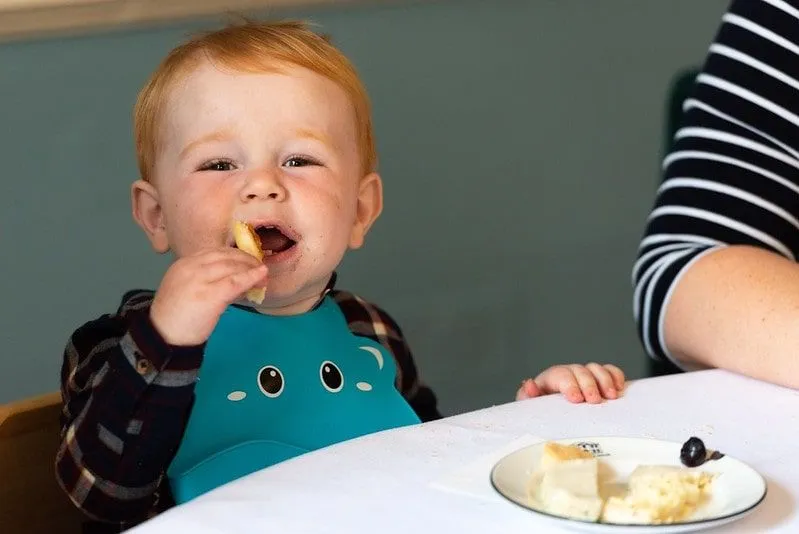 Young boy happily eating his food at afternoon tea.