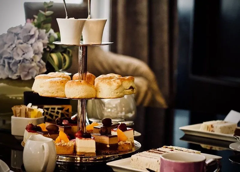 Tiered platter of cakes and scones for delicious afternoon tea.