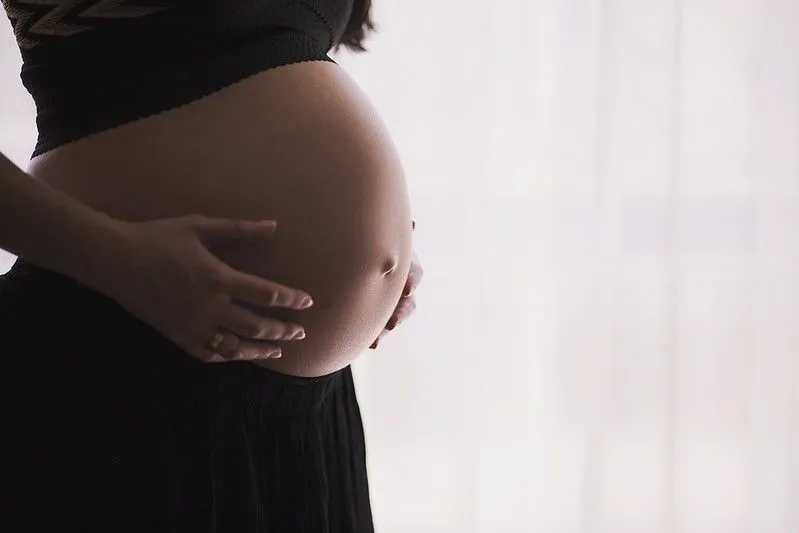 Pregnant woman holding belly. 