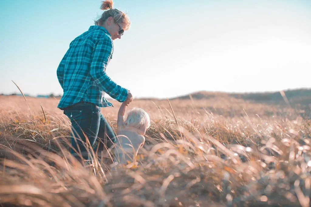 Mother holding child's hand in the lovely English countryside