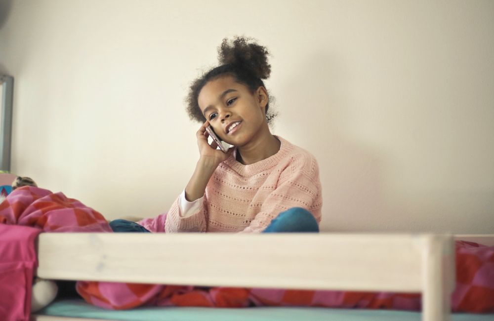 A young girl talks on her Mint Mobile phone.